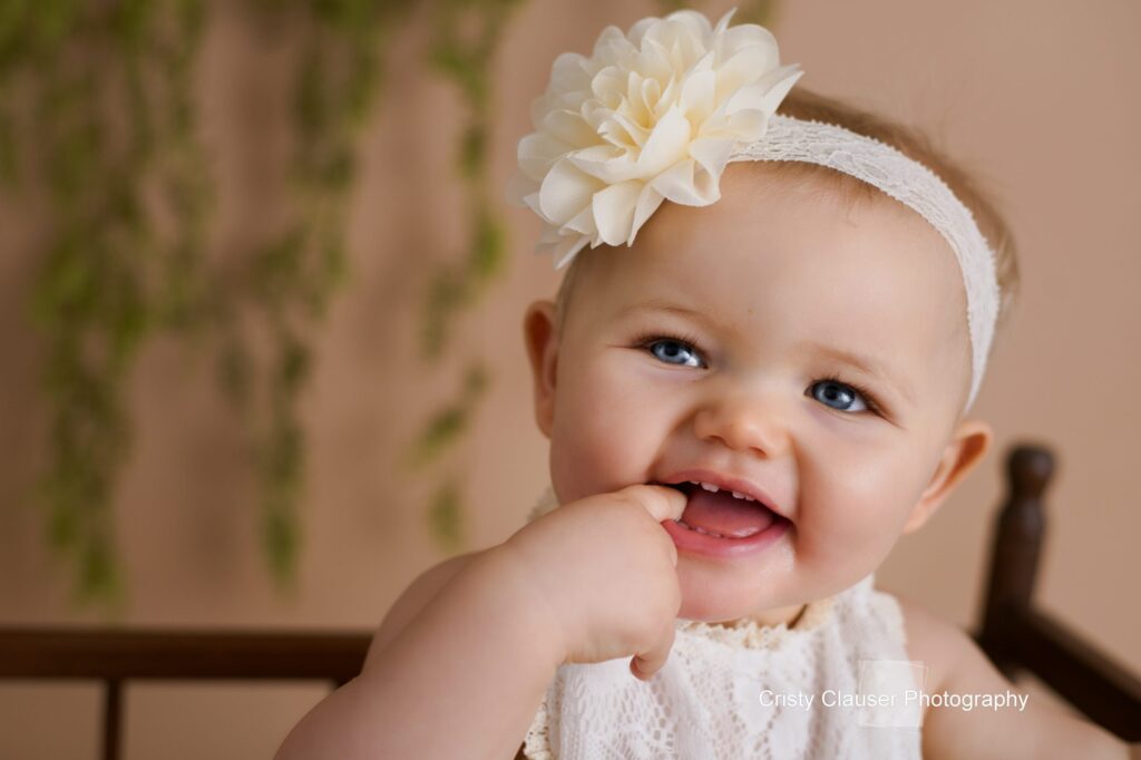 Close-up of smiling baby with finger in mouth